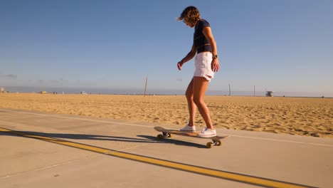 Glückliches-Mädchen,-Das-Sich-Beim-Skateboarden-Auf-Asphaltstraße-Im-Wüstenpark-Umdreht