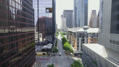 Aerial-view-flying-over-a-street-and-between-high-rise-in-sunny-Austin,-Texas,-USA