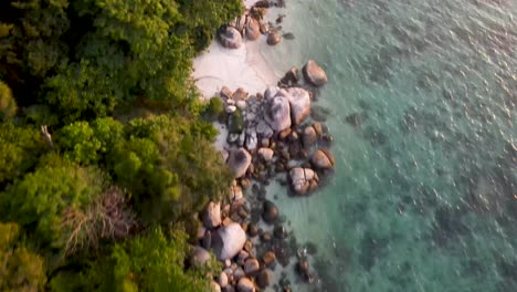 Aerial-top-down-view-of-rocky-coast-of-Koh-Lipe-tropical-island-at-sunset,-Thailand
