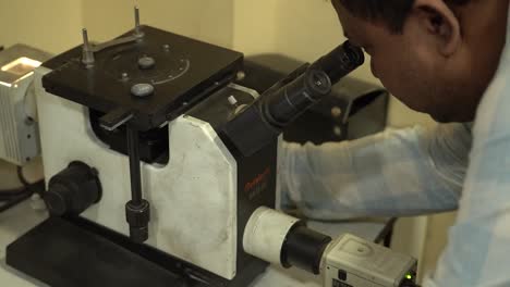 Scientist-using-microscope-in-lab-for-quality-check-of-products,-slow-motion-shot