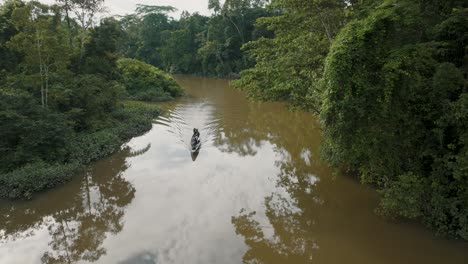 Luftaufnahme-Eines-Kleinen-Bootes,-Das-Auf-Dem-Amazonas-Mit-üppiger-Vegetation-In-Ecuador-Segelt---Drohnenaufnahme