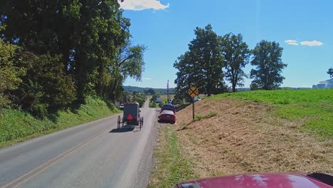 An-Amish-Horse-and-Buggy-Trotting-Down-a-Country-Road-Passing-Cars,-on-a-Beautiful-Sunny-Day