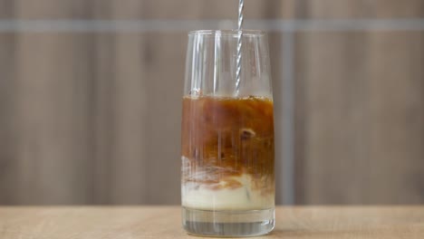 Kondensmilch-In-Schwarzen-Vietnamesischen-Eiskaffee-Einrühren