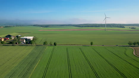 Malerische-Aussicht-Auf-Eine-Landstraße-Auf-Einer-Riesigen-Grünen-Wiese-Mit-Windkraftanlagen-Tagsüber