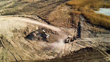 A-large-construction-site-with-bulldozers-moving-dirt-and-causing-dust---aerial-view