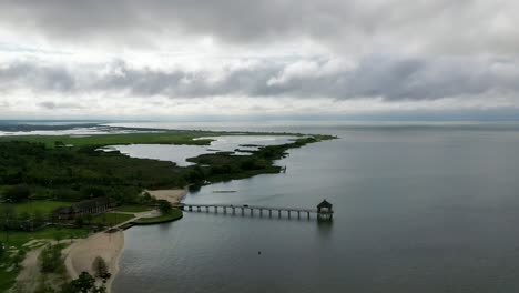 Fontainebleau-Beach-Pier-In-Lake-Pontchartrain-Basin,-Mandeville,-Louisiana-On-A-Cloudy-Day---aerial-drone-shot