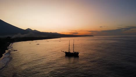 old-wooden-pirate-boat-anchored-at-the-beach-for-sunset