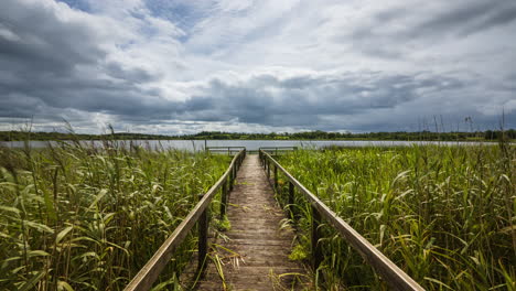 Time-lapse-of-an-old-timber-jetty-leading-to-local-lake-in-rural-landscape-of-Ireland