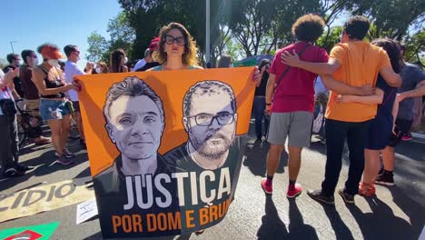Eine-Dame-Demonstriert-Mit-Einem-Banner-Mit-Den-Fotos-Des-Ermordeten-Briten-Dom-Phillips-Und-Des-Brasilianers-Bruno-Pereira-Auf-Der-Straße-Bei-Der-Demonstration-Gegen-Die-Morde-In-Der-Stadt-Brasilia