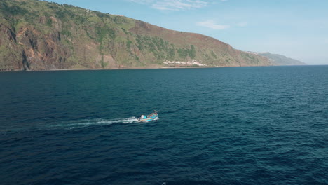 Local-fishing-vessel-out-to-go-fishing-along-rugged-coastline-of-Madeira