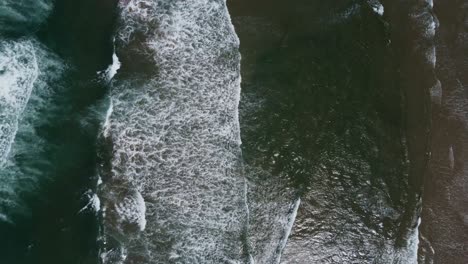 Overhead-drone-shot-of-waves-crashing-onto-the-Oregon-coast
