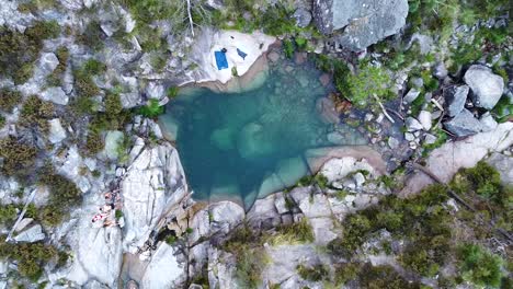 Small-blue-lagoon-created-from-waterfall-in-Peneda-Geres-National-Park,-Portugal,-Europe---drone-going-down
