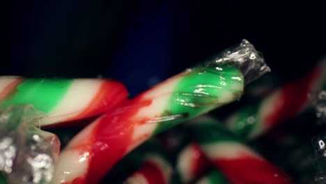 Quickly-pulling-away-from-a-wrapped-red,-white,-green-mini-candy-cane