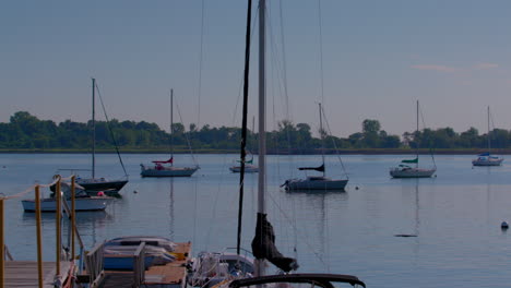 Schwenkaufnahme-Von-Booten-Auf-Dem-Wasser-Der-City-Island-In-New-York,-Von-Der-Barrons-Boatyard-Mit-Hart-Island-Im-Hintergrund