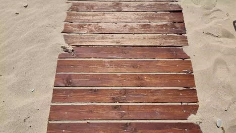 Wooden-boardwalk-on-a-sandy-beach-during-a-warm-summer-day