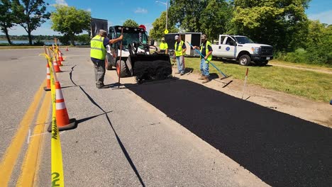 City-paving-crew-smooths-out-fresh-tar-on-road