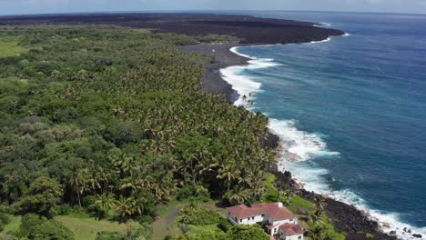 Aerial-descending-and-tilting-up-shot-of-a-brand-new-black-sand-beach-along-the-coast-of-the-Big-Island-of-Hawaii