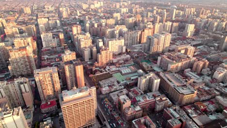 Aerial-dolly-in-of-Downtown-Santiago-crowded-neighborhood-buildings-at-golden-hour,-Chile