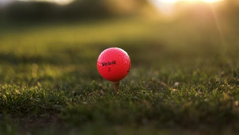 Golfer-Teeing-Off-Volvik-Golf-Ball-on-Driving-Range-at-Sunset,-Close-up