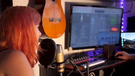 Junge-Frau-Mit-Orangefarbenen-Haaren-Singt-In-Ein-Professionelles-Mikrofon,-Um-Im-Heimischen-Musikproduktionsstudio-Musik-Zu-Produzieren-|-Zeitlupenzoom-In-Aufnahmen-Eines-Hausgemachten-Musikproduktionsstudios