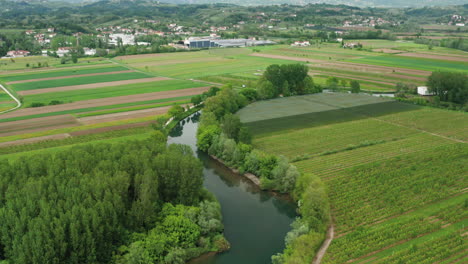 La-Hermosa-Campiña-De-Vipava-En-Eslovenia-Con-Río,-Campos-Agrícolas-Y-Casas-Al-Fondo