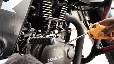 Mecánico-Usando-Tela-De-Fibra-Y-Bomba-De-Aire-Comprimido-Para-Limpiar-El-Motor-En-Honda-Cbf150f