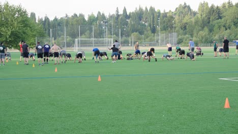 Many-men-gathered-on-a-soccer-field-to-exercise