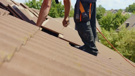 Technician-removing-nails-from-rooftop-tiles-for-installing-solar-panels-base