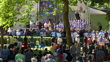 Children-choir-at-outdoor-concert-with-large-crowd-of-people