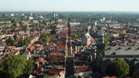 Aerial-View-Of-Sint-Jan-Church,-Historical-Old-Town-Hall-And-Market-Stands-Within-Gouda-City,-Netherlands