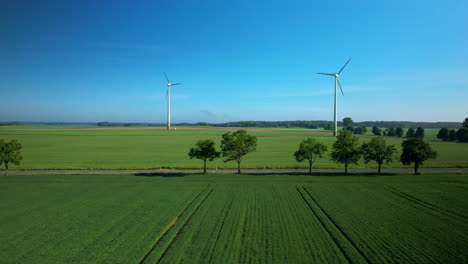 Luftaufnahme-Von-Windkraftanlagen-Im-Grünen-Feld,-Schwenkbewegung-Von-Links-Nach-Rechts