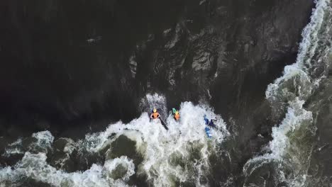Aerial-view-from-above-of-a-kayaker-and-two-bodyboards-descending-the-waters-of-the-Nile-River-in-Jinja,-Uganda