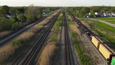 Train-with-steel-coils-and-wood-passing-through-Wyandotte,-Michigan