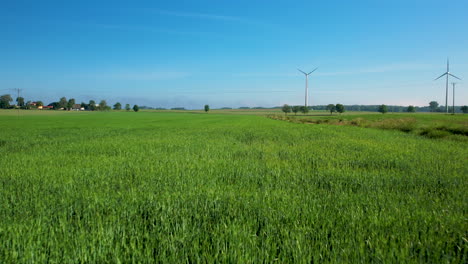 Campos-Verdes-Con-Turbinas-De-Viento-En-El-Fondo---Retroceso-Aéreo