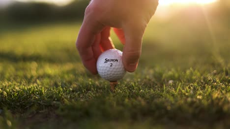 Srixon-Golfball,-Der-Von-Einem-Golfspieler-Auf-Dem-Platz-Aufgeschlagen-Wird-–-Nahaufnahme-Mit-Sonneneruption-Bei-Sonnenuntergang