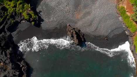 Beautiful-relaxing-4k-drone-shot-in-Maui-Hidden-secluded-beach-with-volcanic-black-sand-private-beach