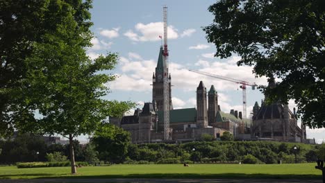 Parliament-of-Canada-seen-from-Major's-Hill-Park-in-Ottawa,-Canada-on-a-sunny-summer-day-before-Canada-Day---4K