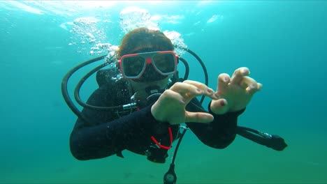 Woman-Enjoying-Scuba-Diving-Waving-at-the-Camera-Underwater-FHD