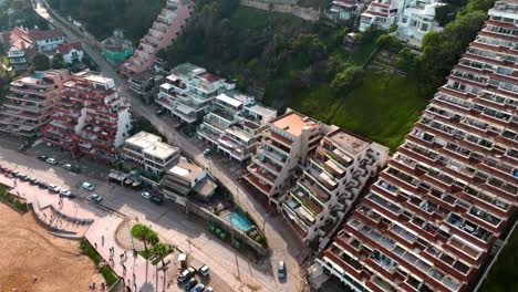 Aerial-dolly-in-of-luxury-houses-and-apartments-in-hillside-near-the-sand-shore-and-sea-in-sector-5-of-Reñaca,-Viña-del-Mar,-Chile