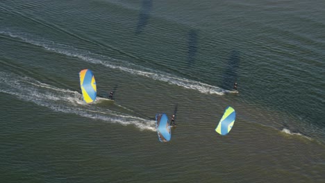 Kiteboarders-being-pulled-fast-across-the-sea-water-by-power-kites