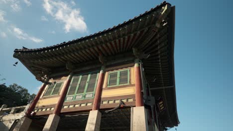 Bongeunsa-Tempel-–-Wolken-Vergehen-Im-Zeitraffer-über-Dem-Alten-Koreanischen-Traditionellen-Pagodengebäude-Mit-Ziegeldach-Und-Bunten-Holzschnitzereien,-Die-Auf-Betonsäulen-Stehen