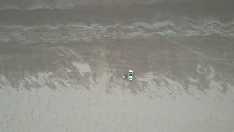Rising-drone-car-parked-on-Inch-beach-Dingle-peninsula-Ireland-overhead-drone-aerial-view