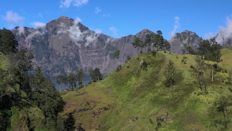 Nubes-Atrapadas-En-El-Lago-Del-Cráter-Del-Volcán-Activo-Monte-Rinjani-En-Indonesia,-Toma-Aérea-Izquierda-Revelada