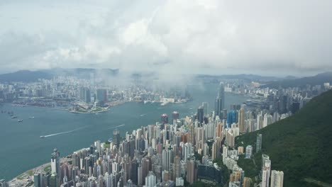 Aerial-perspective-though-clouds-of-Victoria-Habour,-Hong-Kong-skyscrapers-Island-District
