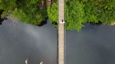 Aerial-view-over-a-bridge-in-the-middle-of-the-river,-in-a-park-in-Europe
