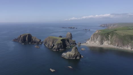 Flat-grassy-plateau-tops-rugged-rock-islet-off-ocean-cliffs-of-Ireland