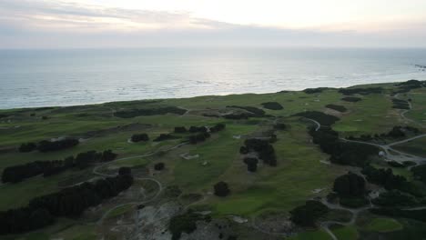 Golf-Course-Fairways-and-Links-on-Coastal-Bandon-Dunes,-Oregon---Aerial-Tilt-up-Reveal