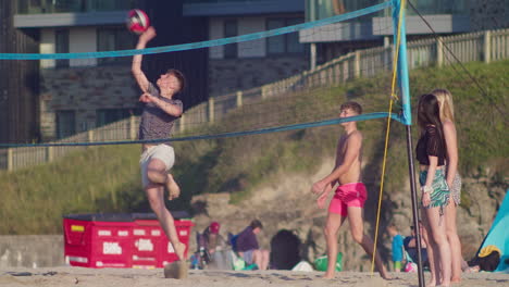 Beachvolleyball-Spielen-Mit-Jungen-Touristen-Am-Strand-Von-Perranporth-In-Cornwall,-England,-Vereinigtes-Königreich