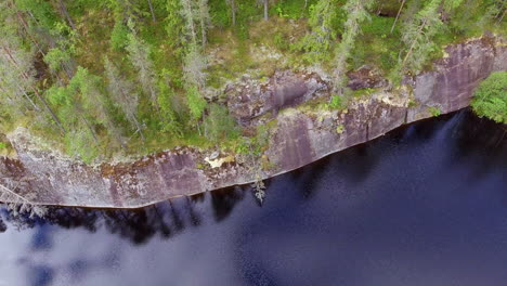 Drone-shot-of-a-water-polished-steep-cliff-in-the-boreal-wilderness
