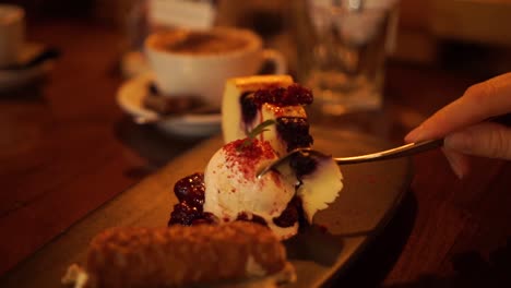 Female-eating-sweet-cheese-cake-dessert-with-ice-cream-with-spoon-in-cozy-luxury-restaurant---CLOSE-UP